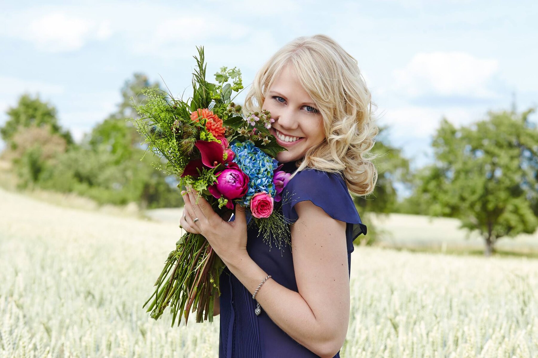 Blonde Frau mit natürlichem Make-up und Blumenstrauß
